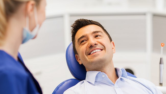 man laying back smiling at dentist