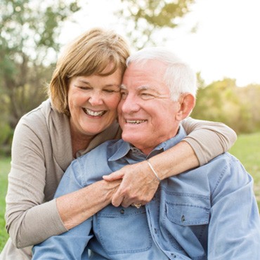 Senior couple smiling outside