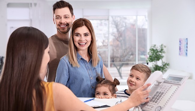 family of four at front desk