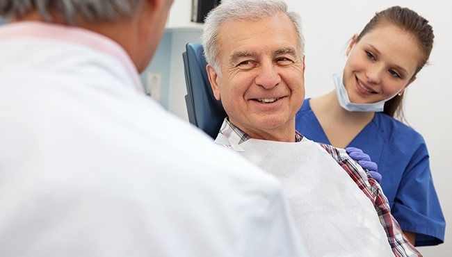 older man smiling in exam chair