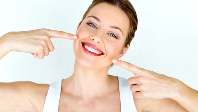 Woman pointing to her smile after direct bonding.