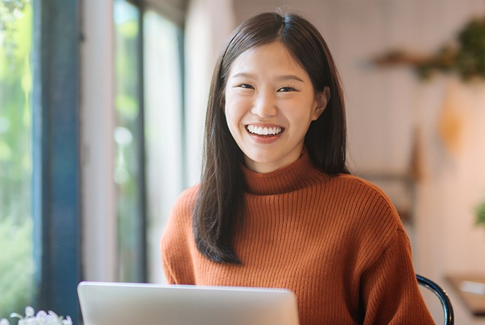 woman wearing orange sweater smiling