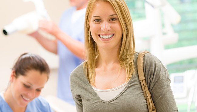 woman in grey shirt smiling at camera