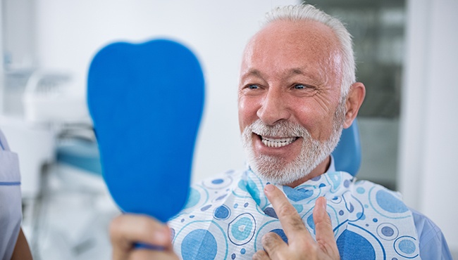 man checking smile in blue mirror