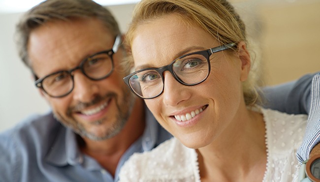 husband and wife smiling with glasses on