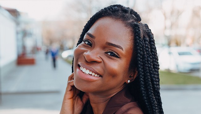woman with braided hair smiling outside