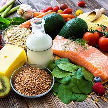 An assortment of healthy foods laid against a wooden background