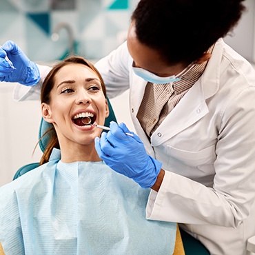 A smiling woman undergoing a dental checkup