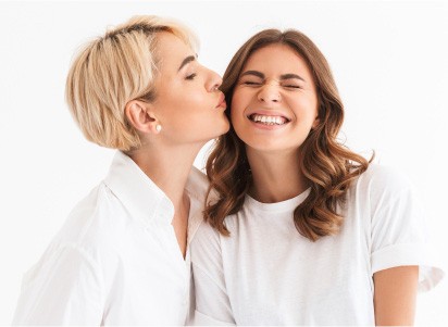 mother kissing daughters cheek