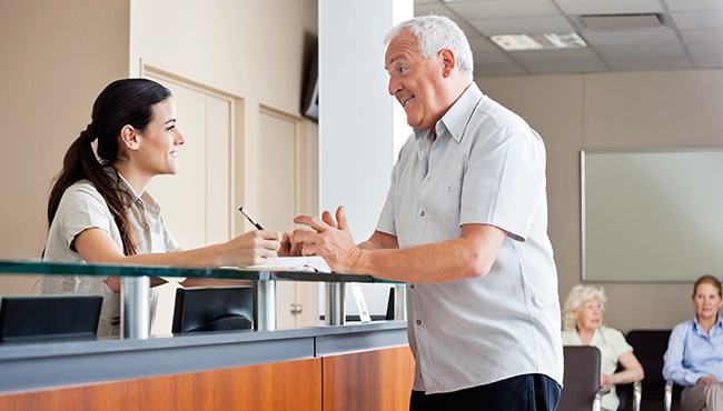 man talking to front desk worker