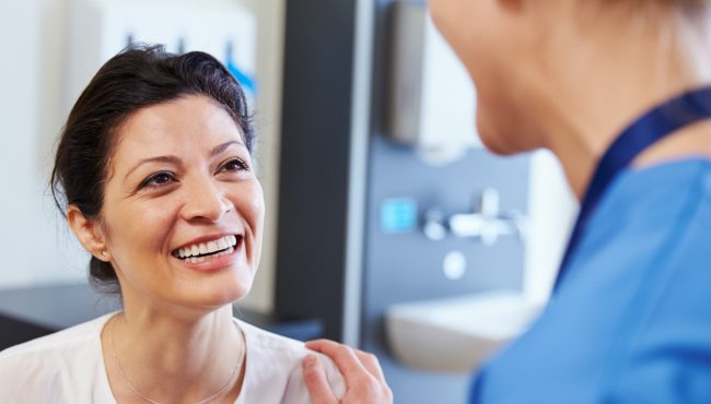 woman in pink smiling at dentist