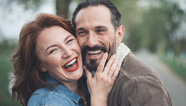 man and woman cheek to cheek laughing