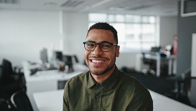 smiling businessperson sitting on their desk