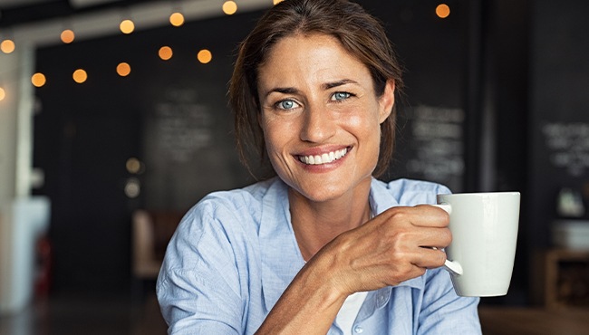 woman holding coffee cup smiling
