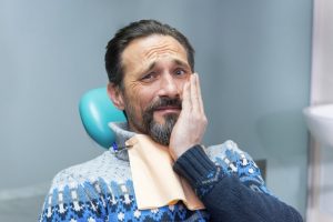 Concerned man hand on cheek visits Buffalo Grove dentist