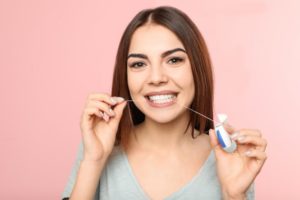 a woman flossing her teeth