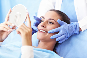 Female patient visiting dentist and checking smile in mirror