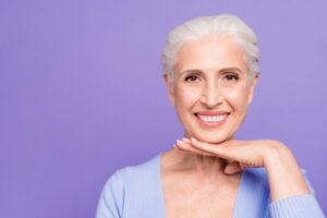 Older woman with dentures smiling. 